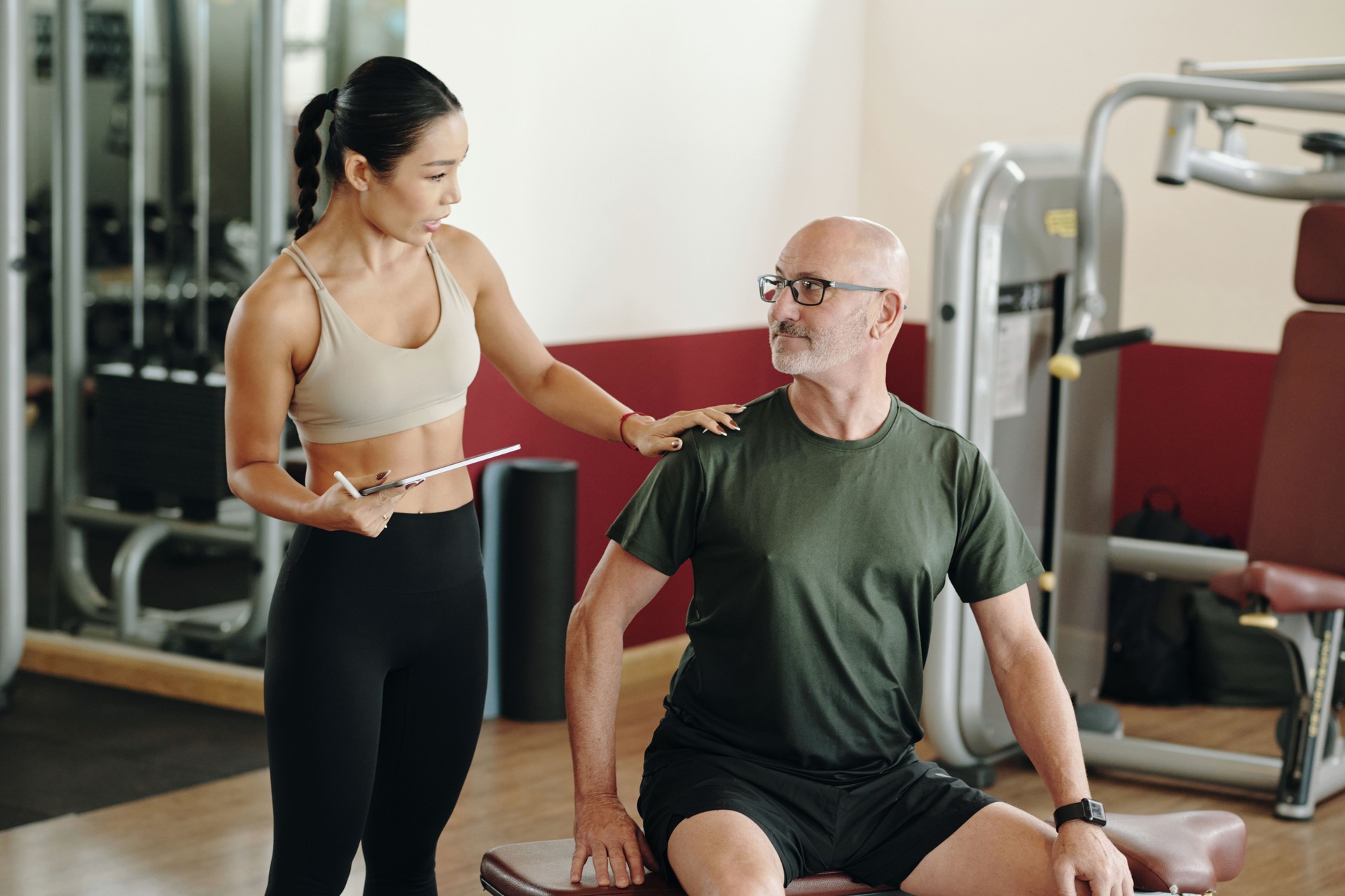 Fitness Trainer Coaching Senior During Workout Session