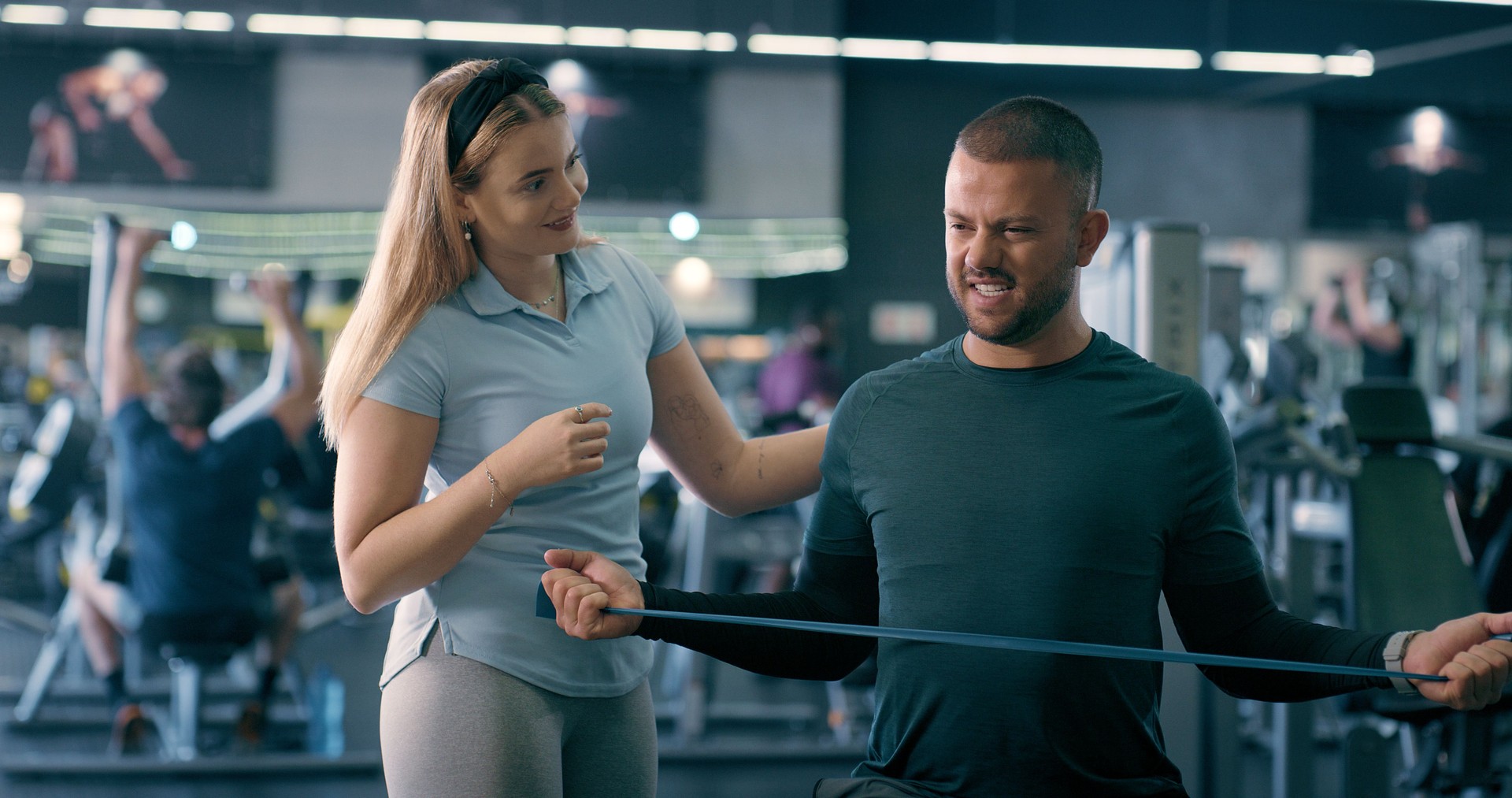 Physiotherapist, woman and man with resistance band for fitness, workout and gym guide or teaching. Coach, help and strong at class for training, learning or rehabilitation exercise at wellness club