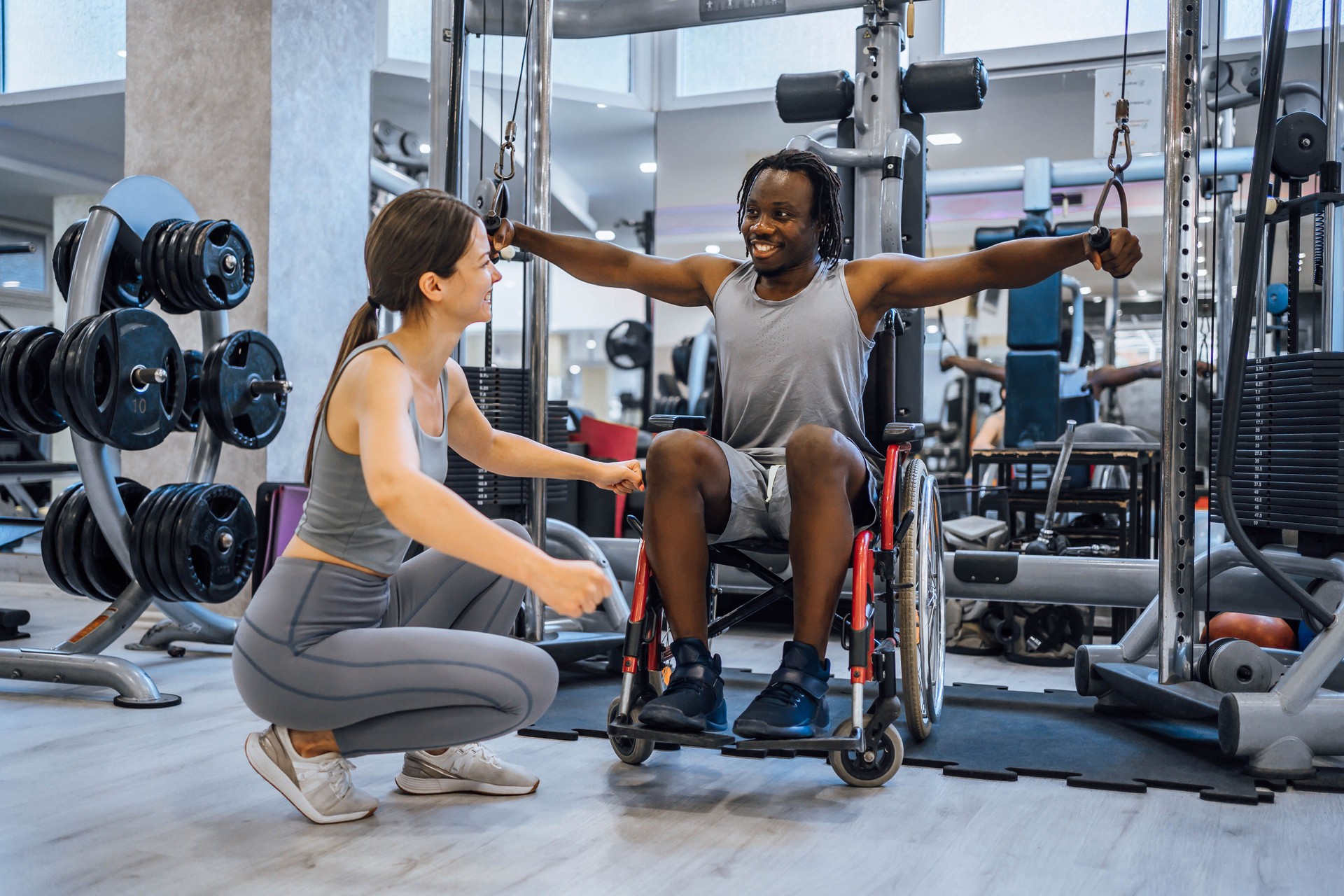 Disabled young man exercising with his instructor